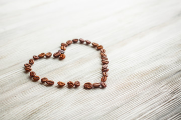 Heart of coffee beans on a white board