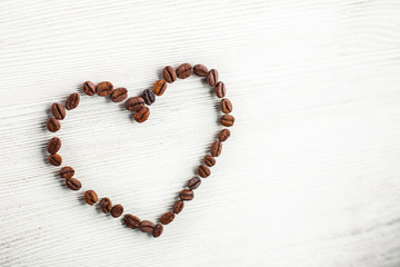 Heart of coffee beans on a white board
