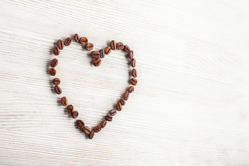 Heart of coffee beans on a white board