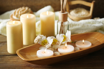 Fototapeta na wymiar Composition of spa treatment, candles in bowl with water