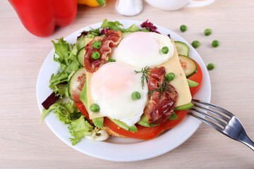 Sandwich with poached eggs, bacon and vegetables