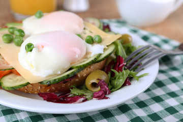 Sandwich with poached eggs, cheese and vegetables