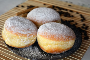 Donuts with powdered sugar on the brown plate