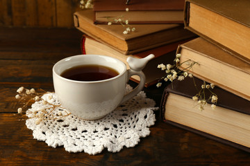 Cup of tea with books on wooden background - obrazy, fototapety, plakaty