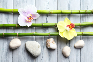 Orchid flowers  and bamboo with pile stones on wooden