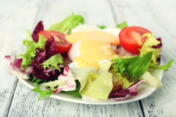Toast with egg Benedict and tomato on plate on wooden table