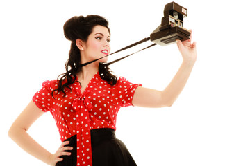 Retro. Pinup girl taking photo with vintage camera
