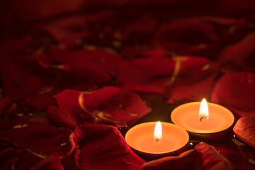 Two candles and rose petals