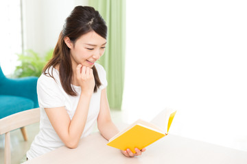 Fototapeta premium 部屋で本を読む女性