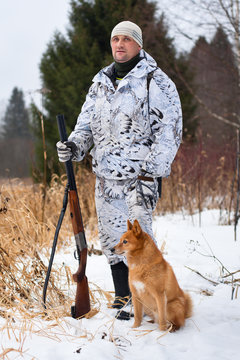 hunter with gun and dog in winter