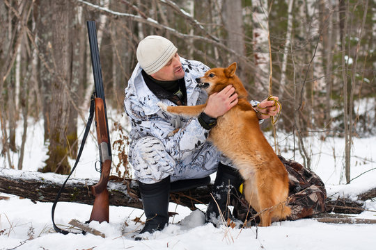 hunter with his dog during the rest on winter hunting