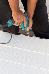 carpenter hands using electric drill on wood
