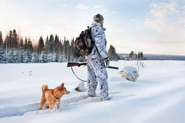 Papier Peint photo Chasser chasseur avec chien sur la route enneigée