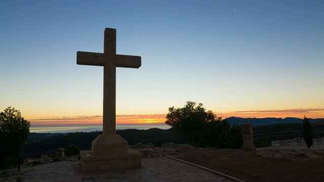 Huge cross against the background of a sunrise