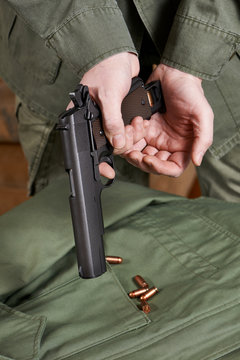 Soldiers load clip with cartridges into gun Colt