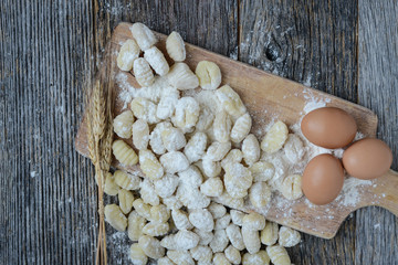 Gnocchi on Cutting Board and Rustic Wood Background