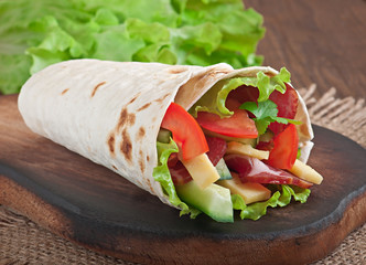 Fresh tortilla wraps with meat and vegetables on plate