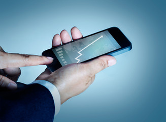 businessman touch mobile phone graph and statistics rising