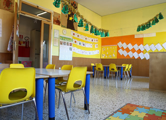 kindergarten classroom with chairs and table with drawings of ch