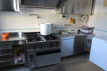 industrial kitchen with big gas stove and the giant aluminum pot