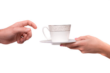 Hand giving cup and saucer