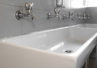 steel taps in white ceramic sink