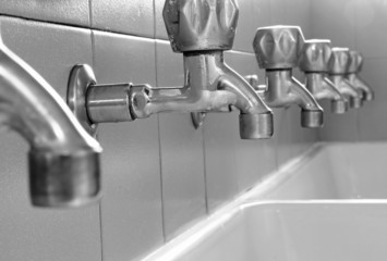 steel taps in white ceramic sink