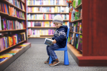 Adorable little boy, sitting in a book store © Tomsickova