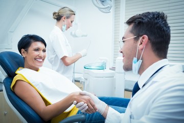 Obraz premium Male dentist shaking hands with woman