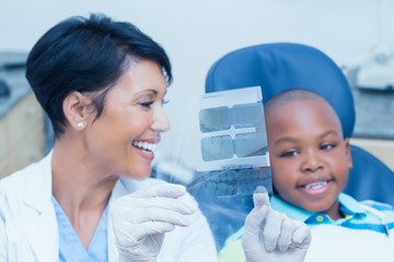 Female dentist showing boy his mouth x-ray