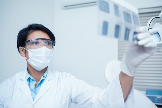Concentrated dentist looking at x-ray
