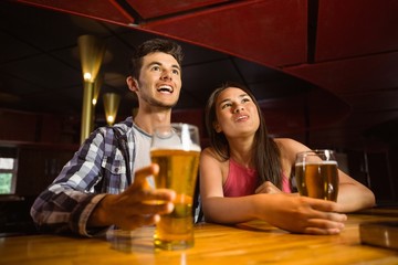 Smiling friends drinking beer together