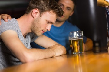 Caring friend comforting upset man