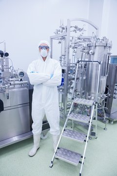 Scientist In Protective Suit Standing With Arms Crossed