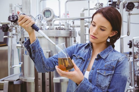 Scientist preparing an experiment with a pipette and beaker - Powered by Adobe
