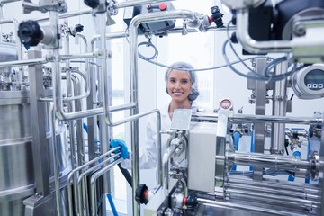 Portrait of a smiling scientist behind metal pipe