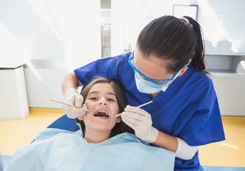 Pediatric dentist using dental explorer and angled mirror
