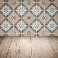 Wood table top and blur vintage ceramic tile pattern wall