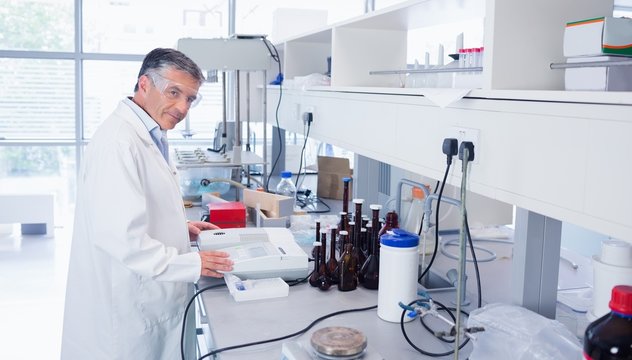 Scientist carrying out an experiment looking at the camera