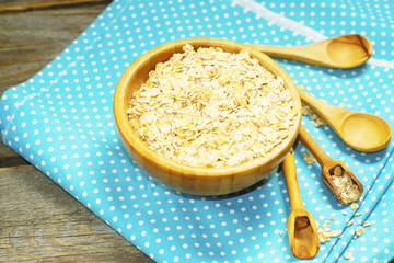 Porridge in the wooden bowl on the wooden rustic surface