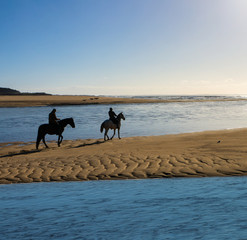 Zwei Reiter am Strand in der Bretagne