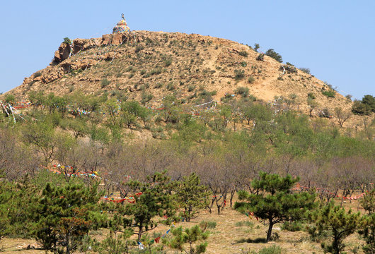 Buddhist stupa with prayers flags on top of hill, Hohhot