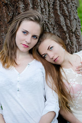 Fototapeta premium pretty girlfriends leaning against big tree