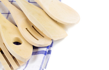 wooden forks, spoons and spatulas on kitchen towel isolated on w