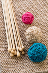 Three colorful balls and wooden needles lying on beige