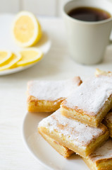 lemon bars on a white plate with slices