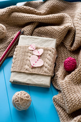 Obraz na płótnie Canvas One old notebook in knitted cover with felt hearts