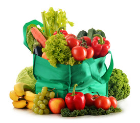 Green shopping bag with variety of fresh organic vegetables isol