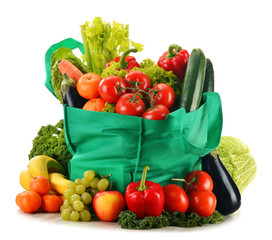 Green shopping bag with variety of fresh organic vegetables isol
