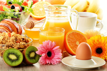 Breakfast with coffee, juice, croissant, salad, muesli and egg